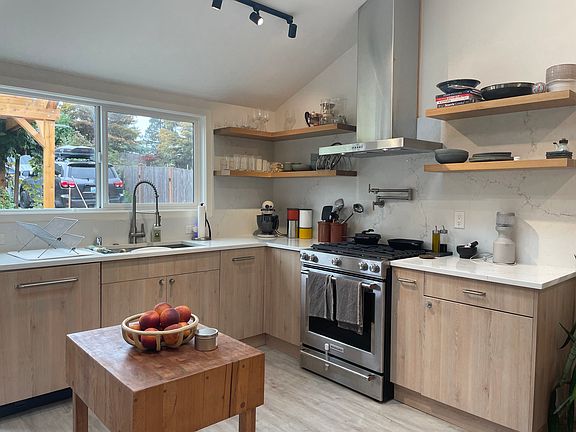 Fully equipped kitchen with large sink, new appliances, panel hidden trash and dishwasher, and pot filler.