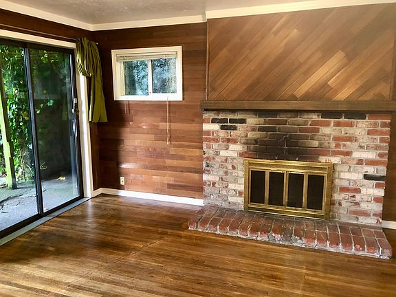 Living room looking south to the sliding glass doors onto the small patio and green space