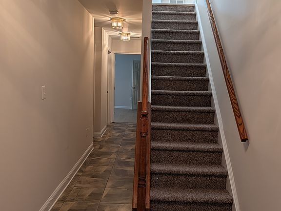 Tile foyer to laundry room and ground floor recreation room, staircase to main living level