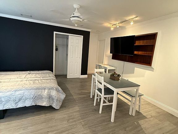 Well-lit studio featuring Smart TV, ceiling fan, and inviting dining space.