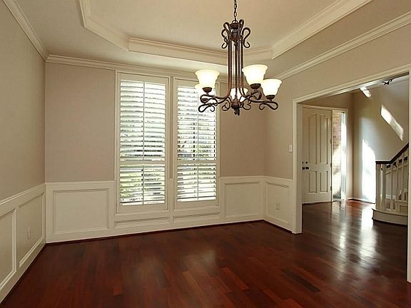 The dining room features a recessed ceiling, and handsome woodworking. Plantation shutters have been installed virtually throughout the downstairs. Updated lighting.