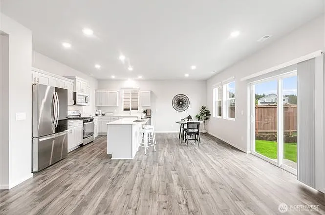 Kitchen with white cabinets and countertops. Stainless steel appliances. large walk-in pantry for storage.
