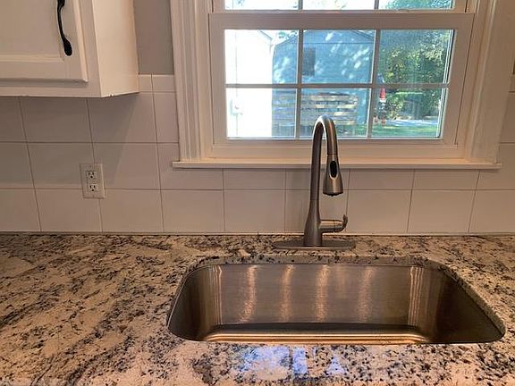 New granite countertops and single bowl stainless steel sink.