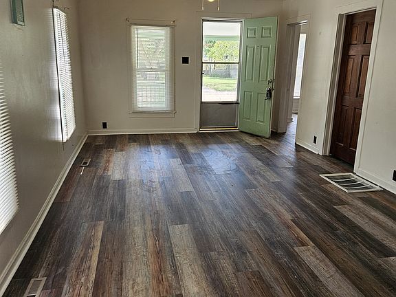 Living and dining rooms, looking toward front door that faces on to Lewellen. Open door on right is to northwest bedroom; closed door on right is to north bedroom