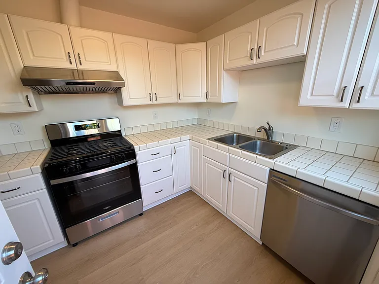 Efficient kitchen is equipped with stainless steel appliances featuring a patio door that opens to a private side yard and backyard.