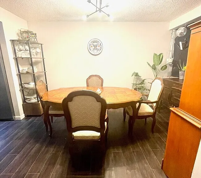 Alternative View: Dining or flex area located off kitchen with dark flooring and space for a dining table, desk, or additional living setup.