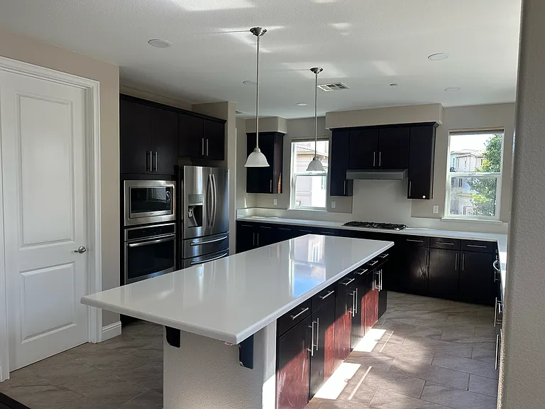Chef's kitchen featuring an oversized island, stainless steel appliances, and ample cabinet storage.