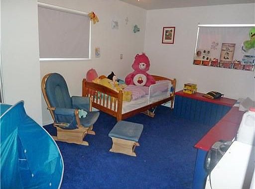 This bedroom has wall-to-wall carpeting and two windows