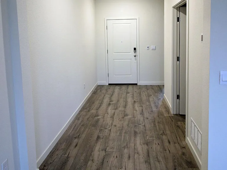 Hallway that leads from the great room to the front entryway door. The open door on the right leads to the laundry room.