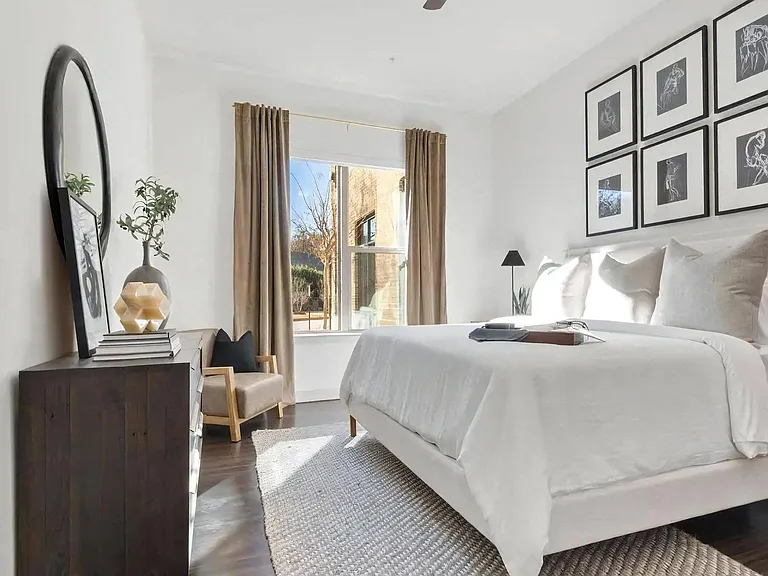 Bright Bedroom with Large Window, Wall Decor, and Dresser