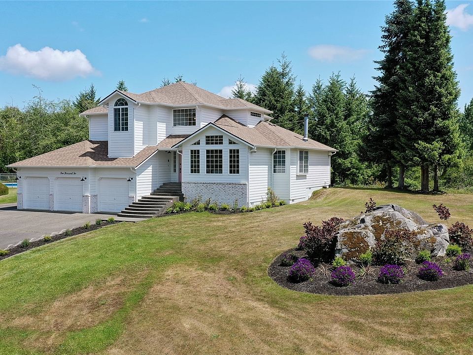 Drone shot of front of home, I love the large decorative rocks throughout the 5 acres, and the nice long driveway.>