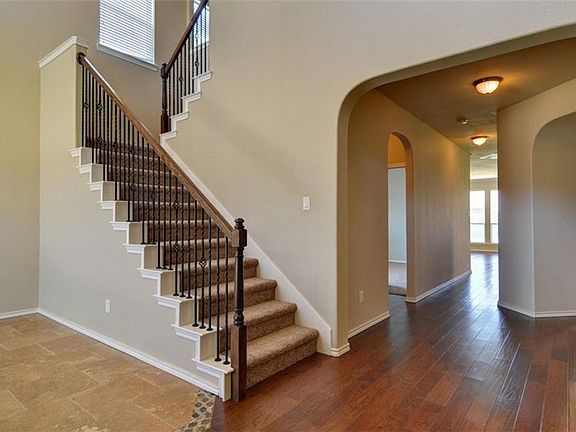 A view from the front door.  Hardwood floors through the entryway into the kitchen, breakfast area and family room.  Wrought iron spindles on the banister.  Ceramic tile floor in the dining room.