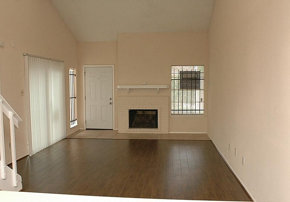 Spacious Living Room with High Ceiling, Brick Fireplace with Mantel and Ceiling Fan