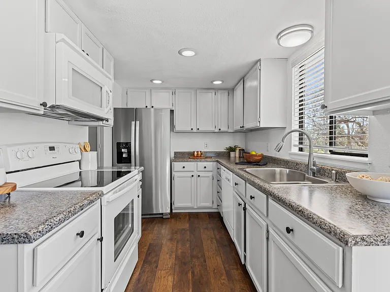 This cozy kitchen features abundant cabinet storage, generous countertop space, and updated stainless steel fridge/freezer.