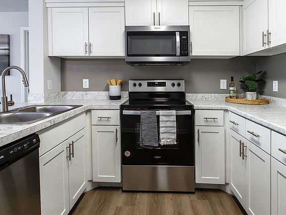 Delight in a culinary escape in our full-equipped kitchens, boasting a sophisticated stainless-steel appliance package including the coveted dishwasher and a mounted microwave over the stove.