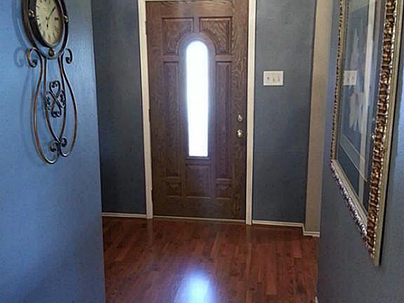 Entry area with coat closet by front door and wood floor