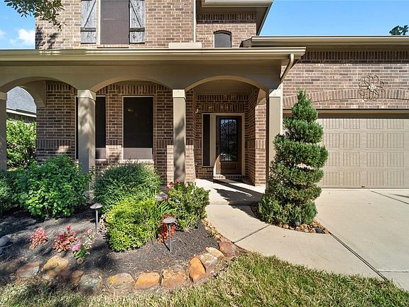Lush landscaping, front elevation shutter, solar screens, cover porch with columns and a beautiful front door