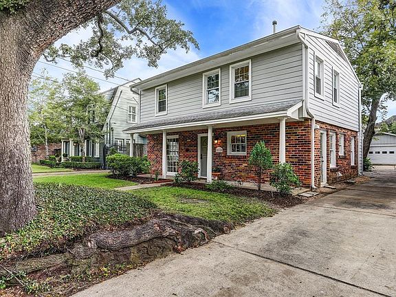 3215 Rice Blvd. View showing mature Oak tree and cheerful exterior with covered porch and pleasant flower bed in the front. See also is the detached 2-car garage that still leaves a good sized fenced back yard. You're right in the middle of West Univ