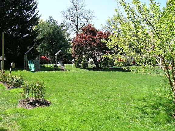 Level back yard with swing set and sandbox
