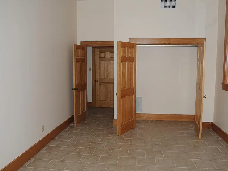 Left bedroom showing closet, entry and one of the windows