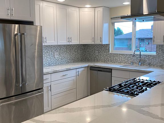 New remodeled kitchen with new tile flooring, shaker cabinets and quartz countertops. Overhanging bar with additional seating.