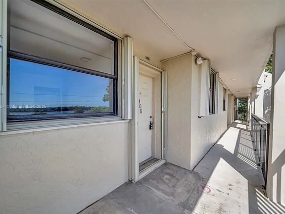 Front entryway with hurricane shutters on both windows and front door.