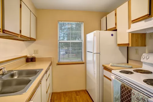 A kitchen with a window overlooking the property, lots of counter space, and plenty of cabinet storage space - Heron View