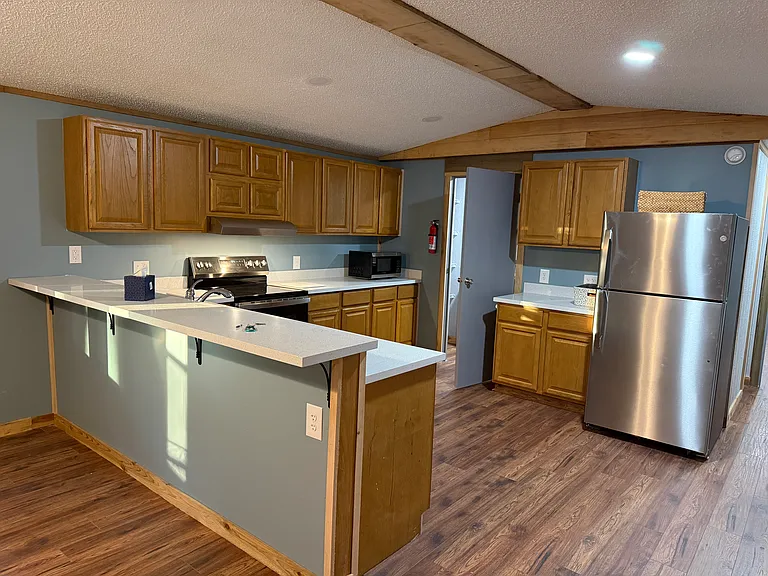 kitchen with Stainless appliances, oak cabinets and solid surface counter tops.