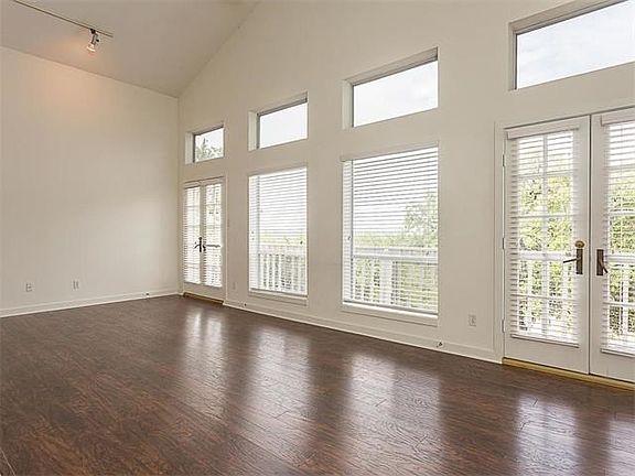Walk into this uplifting living area with it's wall of windows....bright and light!  Notice the two sets of French doors leading onto a wrap-around balcony.  Views of the hill country including 4th of July fireworks from Austin Country Club.