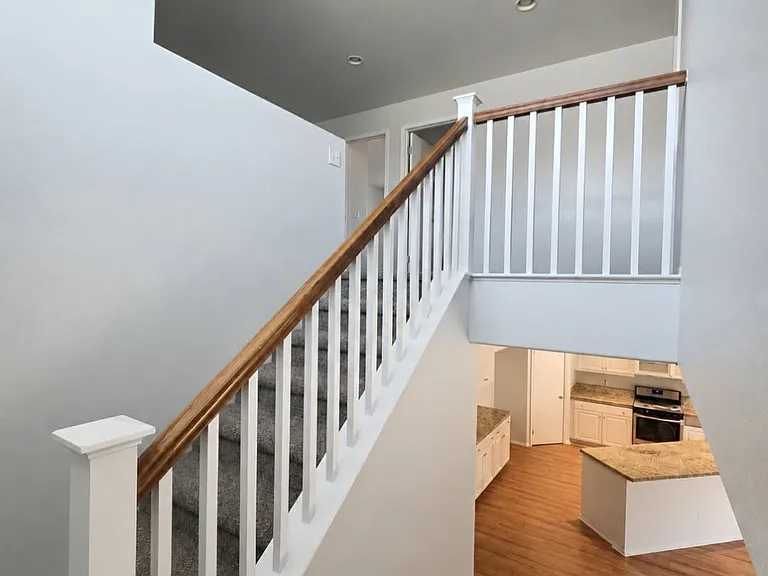 Open staircase overlooking the spacious kitchen and main living areas.