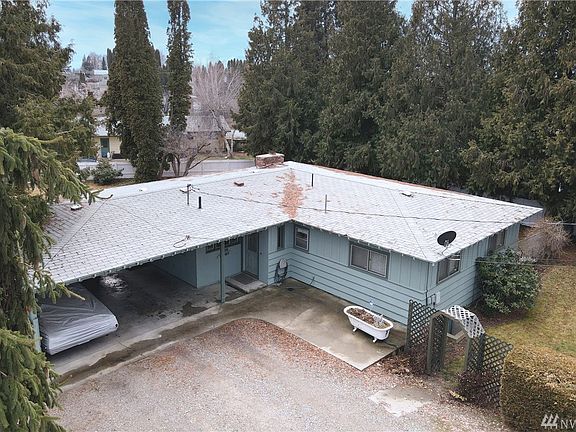 Aerial view showing attached carport & mature trees.