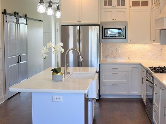 Large gourmet newly built kitchen with island and office or dining room open to family room including fireplace and wine refrigerator.