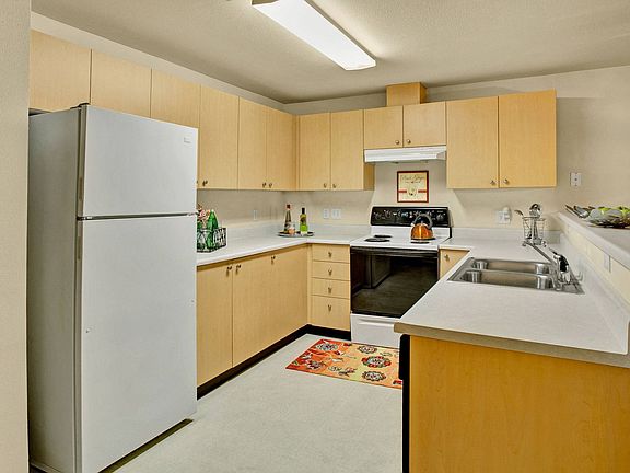A kitchen with lots of counter space cabinet storage, and a bar