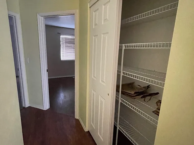 Hall closet and view of two bedrooms
