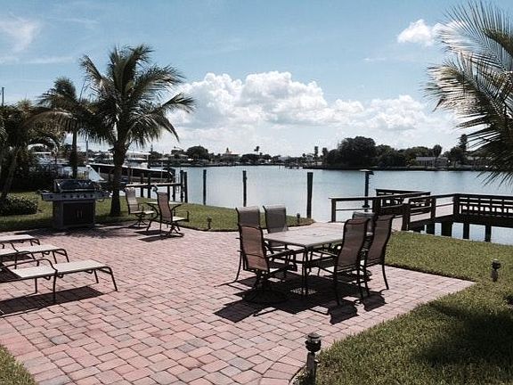 Waterfront patio with furniture and gas grill