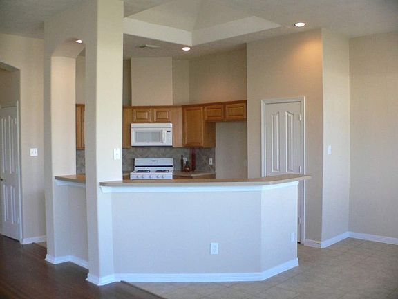 Kitchen is well-designed with gas range, built-in microwave, ceramic backsplash, nice pantry, open t