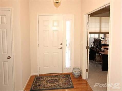 Foyer's front door features a sidelite that lets in extra light to show off the rich warm hardwood flooring