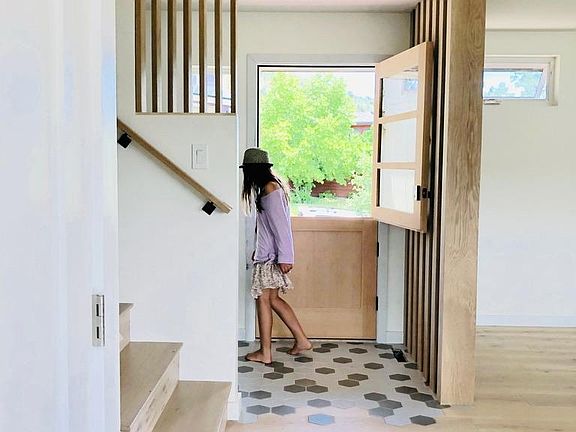 Entry way with french door creates a moment of pause before entering the open plan dining area and kitchen. Stairway leads up to upper level of tri-level house (3 bedrooms, two full baths) and down to W/D and 4th bedroom/full bath.