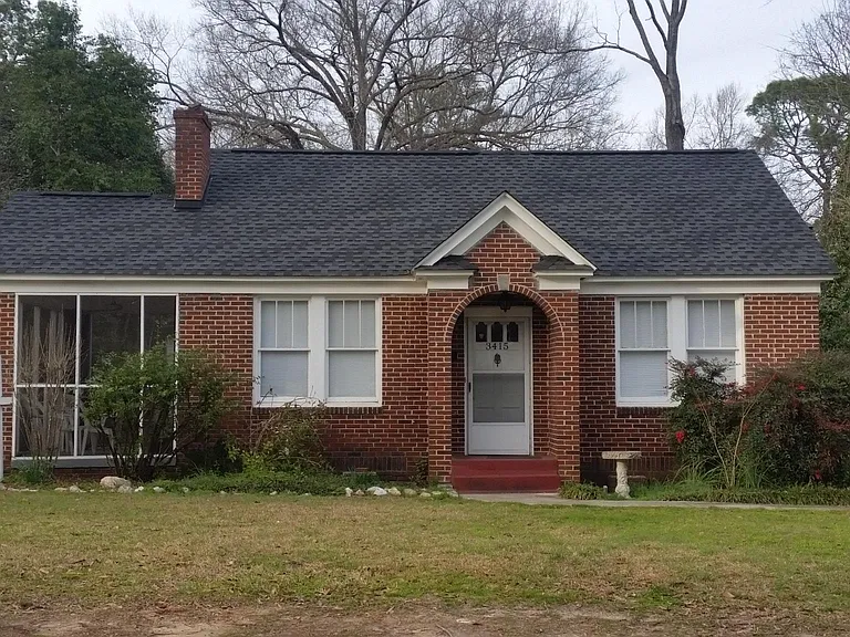The apt is located behind this house.