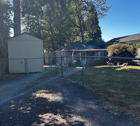 Front of the home from off street parking area. Yard is completely fenced.