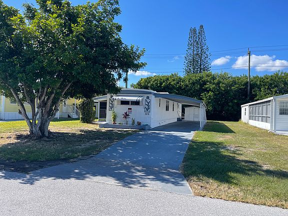 shady side of building with carport with shed, washer and dryer hookups in shed