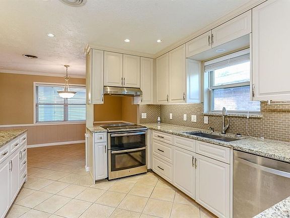LOOK AT THESE BEAUTIFUL RAISED PANEL CABINETS WITH SOFT CLOSE DRAWERS AND DOORS, NEW STAINLESS APPLIANCES, UNDER LIGHTING, BEAUTIFUL NEUTRAL STONE TILE FLOORS AND GRANITE COUNTER TOPS!!!
