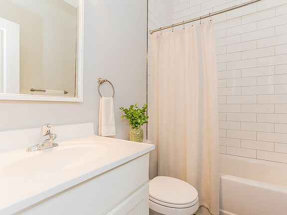 Full bathrooms with tiled tub surrounds.