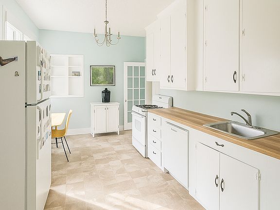 Kitchen with full-size refrigerator, dishwasher, gas stove and ample cabinet storage.