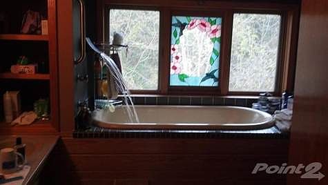 The master bath has this great tub feature.  The stain glass feature still maintains thermal windows and was created by first owner.