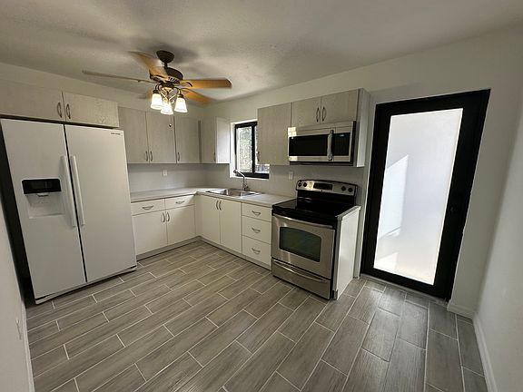 Completely Renovated Kitchen with New Cabinets. Kitchen comes with Refrigerator, Range with Oven and Microwave Oven, and Ceiling Fan.