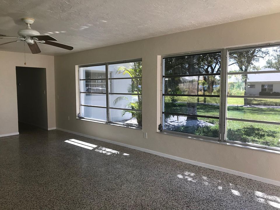 Large light living room with polished terrazzo floors.