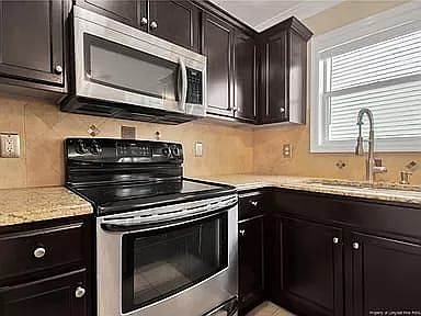 Kitchen with granite countertops, SS appliances with modern lighting throughout