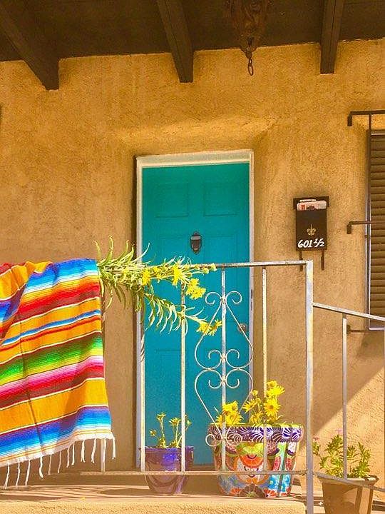 turquoise entrance door into the 1920's adobe apartment, with the portal covered front porch.