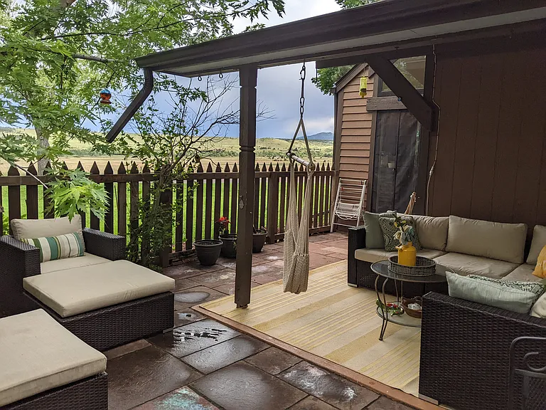 Large partially covered private patio with plenty of seating and open space views.